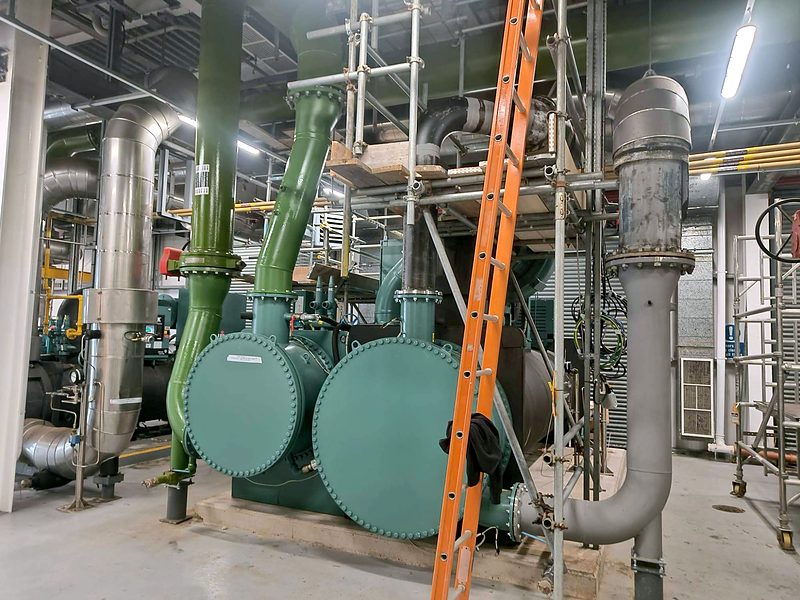 Plant room with large-bore pipework connected to a chiller.